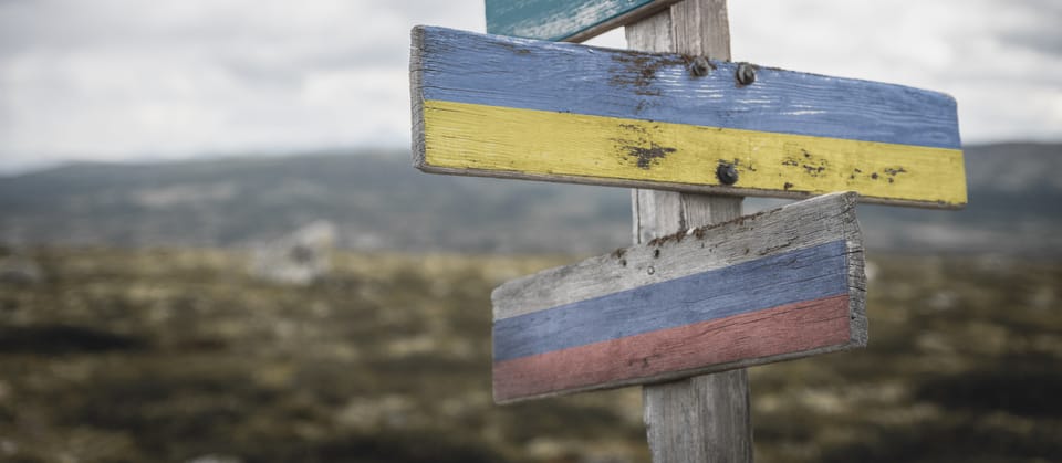 Signpost with Ukrainian and Russian flags